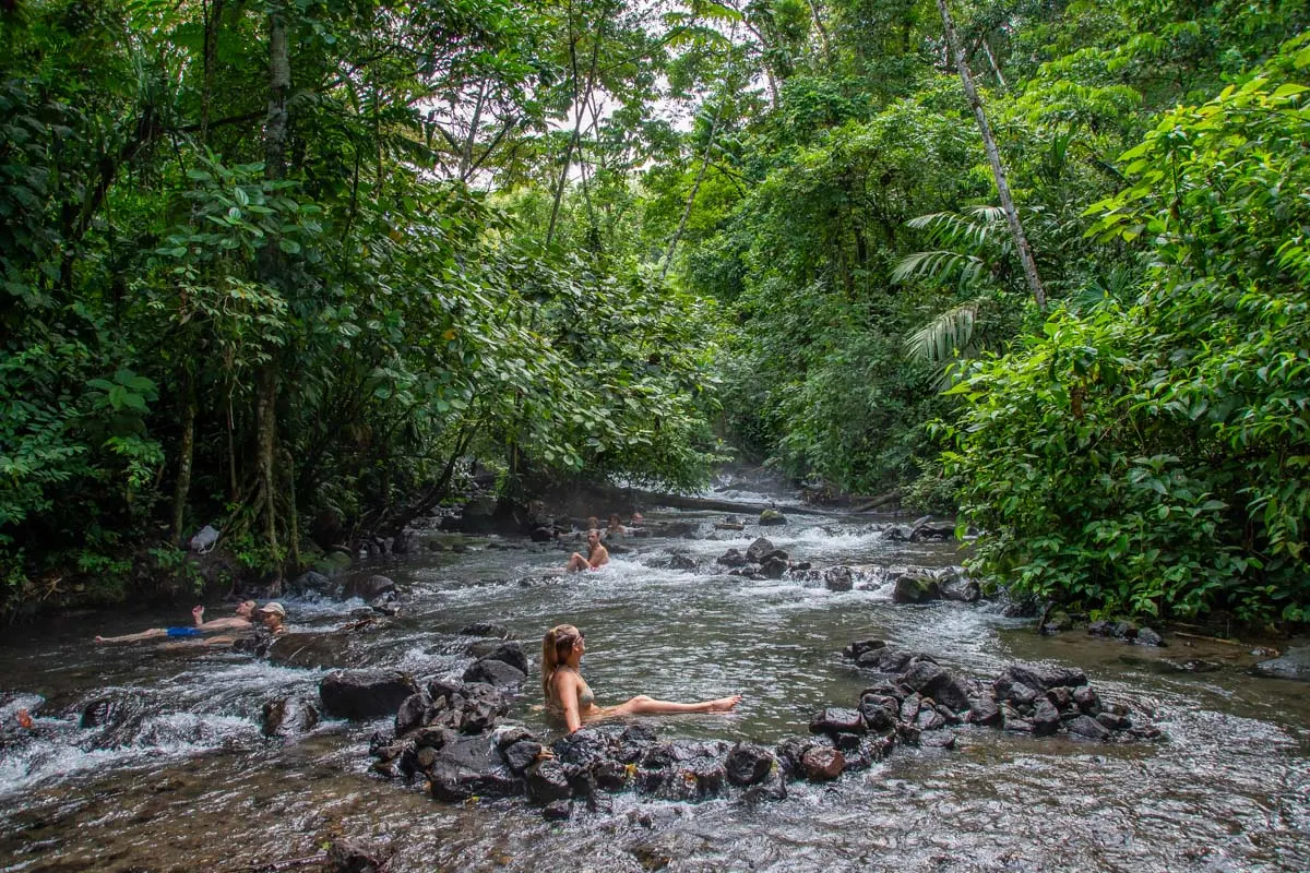 A lady sits in the free hot springs river in La Fortuna
