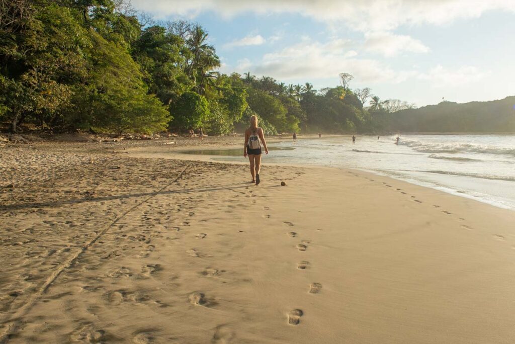 A lady walks along Playa Pelada in Nosara, Costa Rica