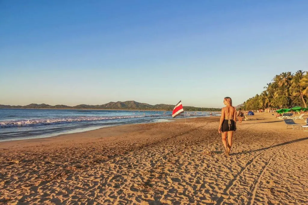 A lady walks along Tamarindo beach