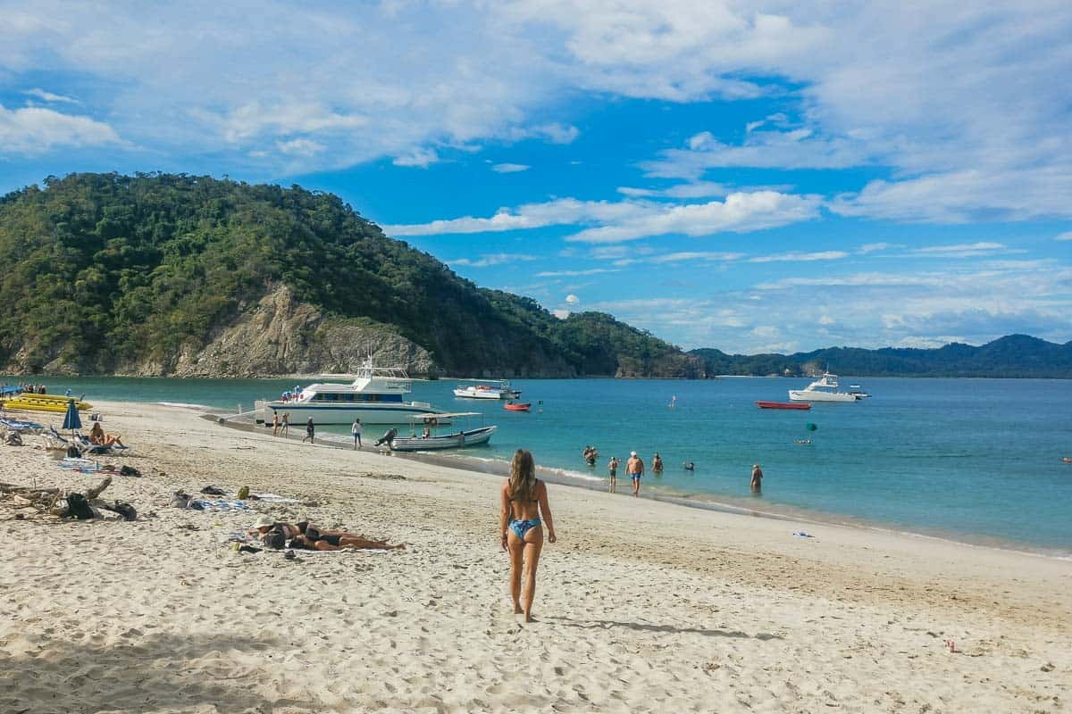 A lady walks on the beach at Tortuga Island on a tour