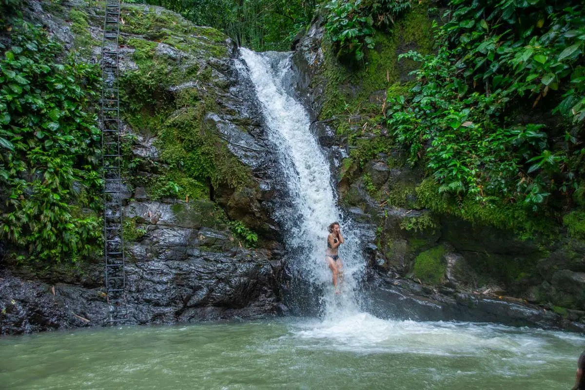 A lady slides down Uvita Waterfall