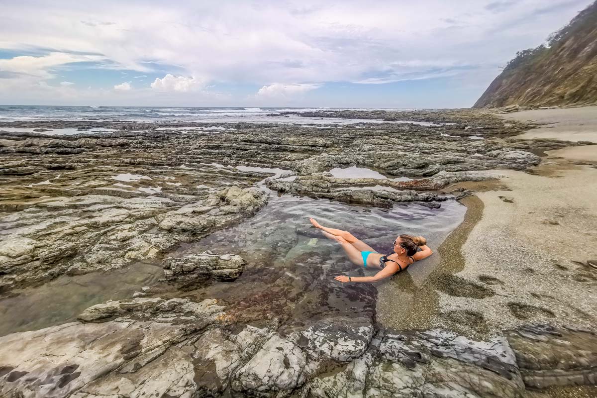 A lady relaxes in  the tidal pools at Izquierda Beach, Samara, Costa Rica
