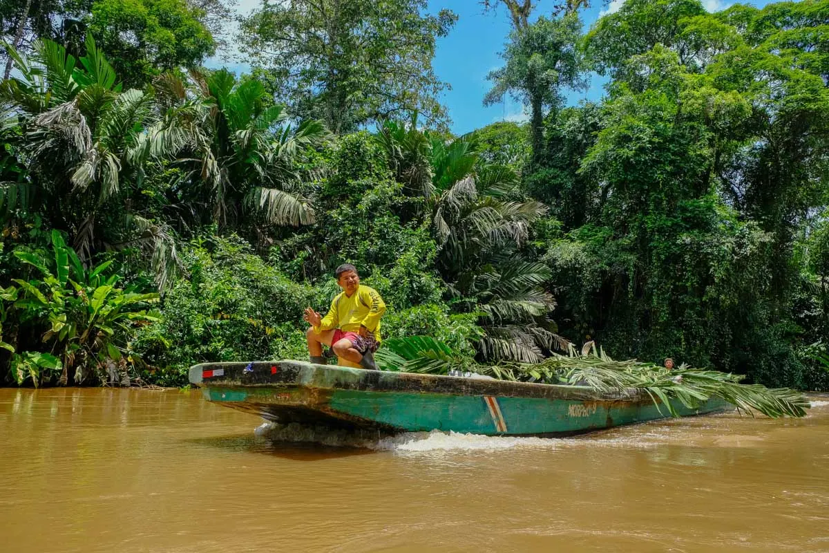 A local drives a boat through Tortuguero National Park