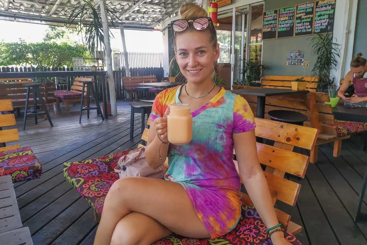 A lady drinks a fresh juice at Manuel Antonio Falafel Bar