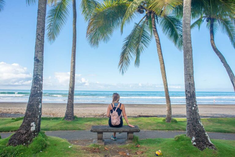 A lady sits on a bench at Jaco Beach, Costa Rica
