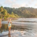 A lady walks along Jaco Beach at sunset
