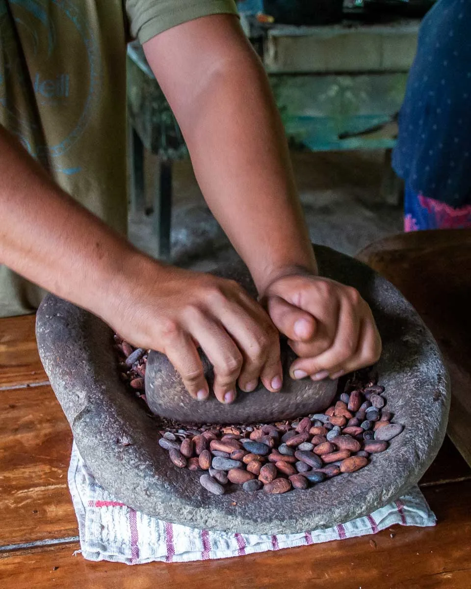 Grinding Cacao Beans on a chocolate tour in La Fortuna