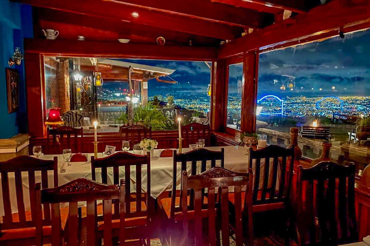 A view of a table with the backdrop of San Jose, Costa Rica at Restaurante Mirador Ram Luna view at night over San Jose