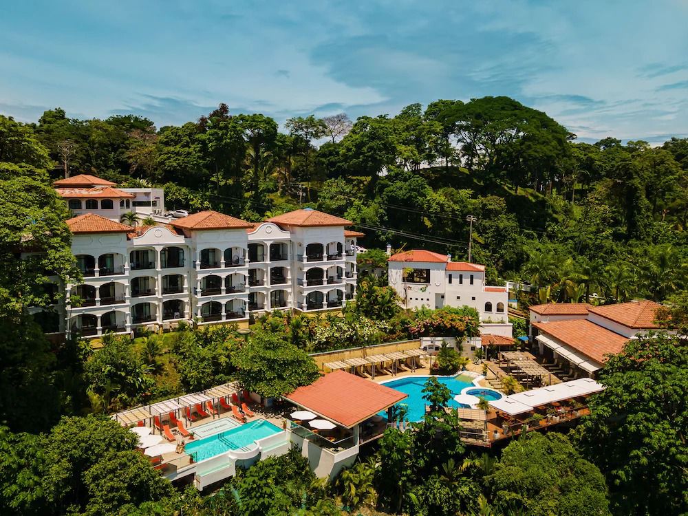 aerial view of Shana by the Beach Manuel Antonio with the large white apartnment rooms and pool surrounded by thick green jungle