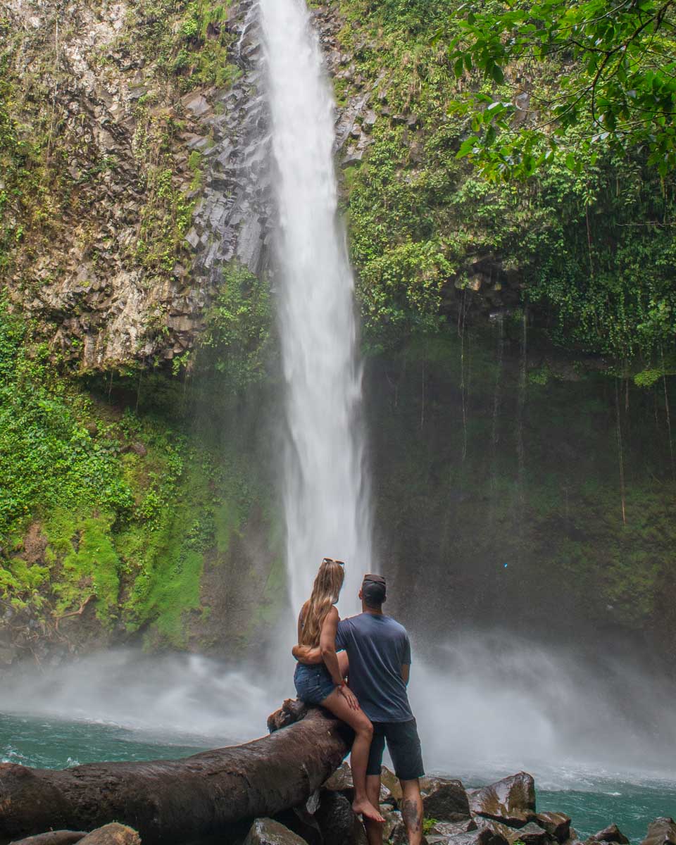 A couple take a photo at La Fortuna Waterfall, Costa Rica