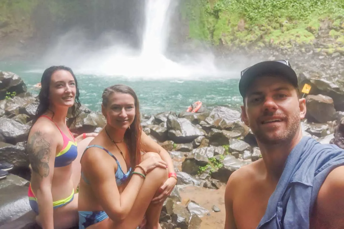 Three people take a selfie at La Fortuna Waterfall