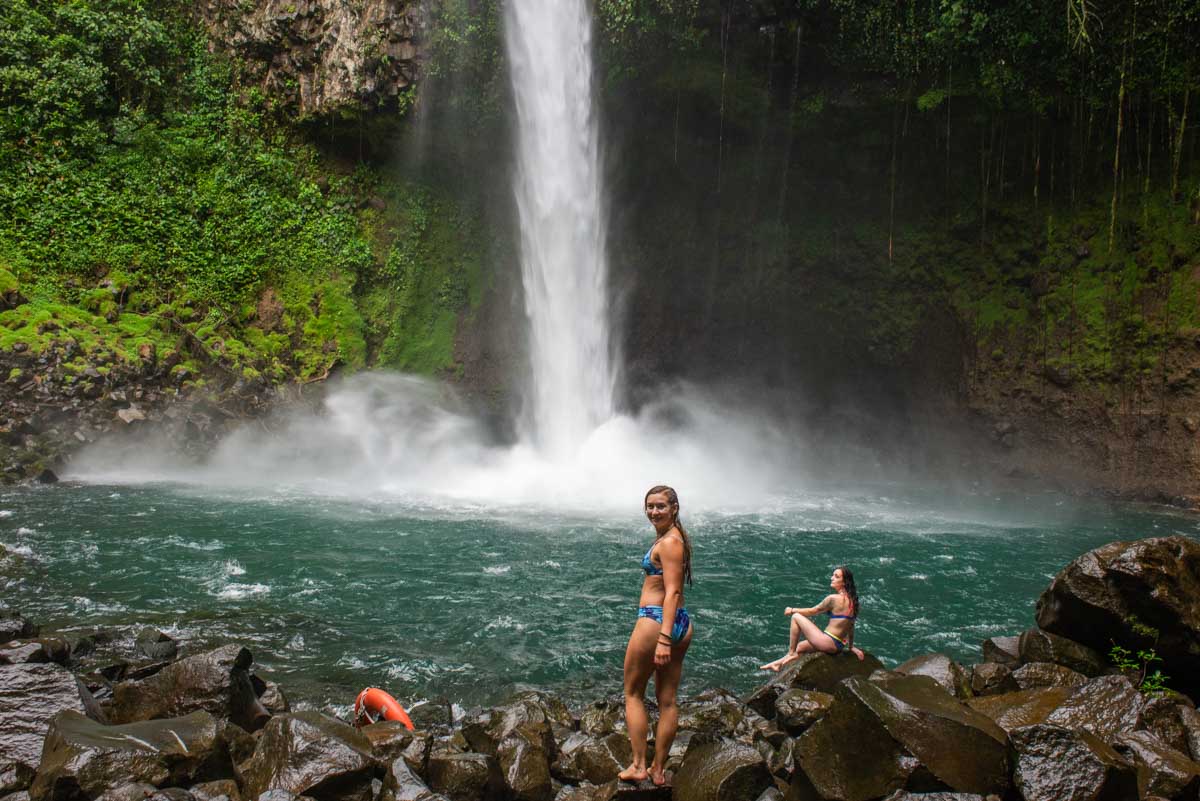 Two girls pose for a photo at La Fortuna Waterfall, Costa Rica