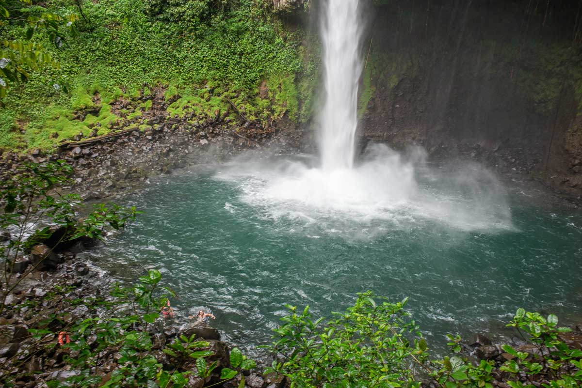 View of La Fortuna Waterfall while two people swim