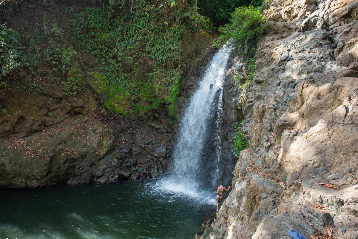 A lady stands below the Montezuma Waterfall in Costa Rica