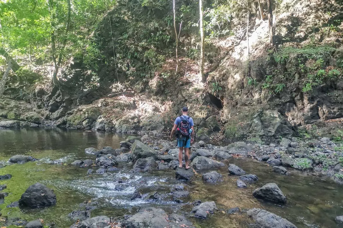 Daniel crosses the river to access the Upper Montezuma Waterfalls in Costa Rica
