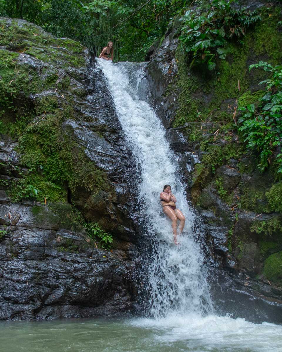 A lady slides down Uvita waterfall, Costa Rica