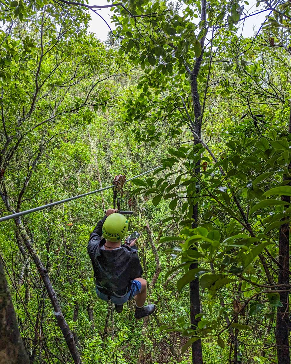A man begins a zipline in Jaco