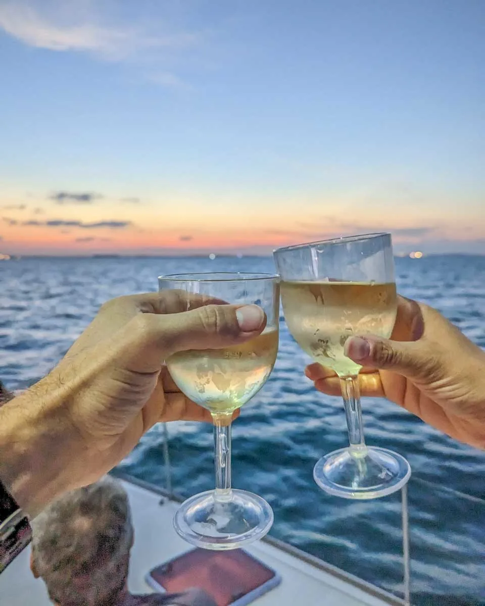 Two people cheers wine on a sunset cruise in Tamarindo, Costa Rica