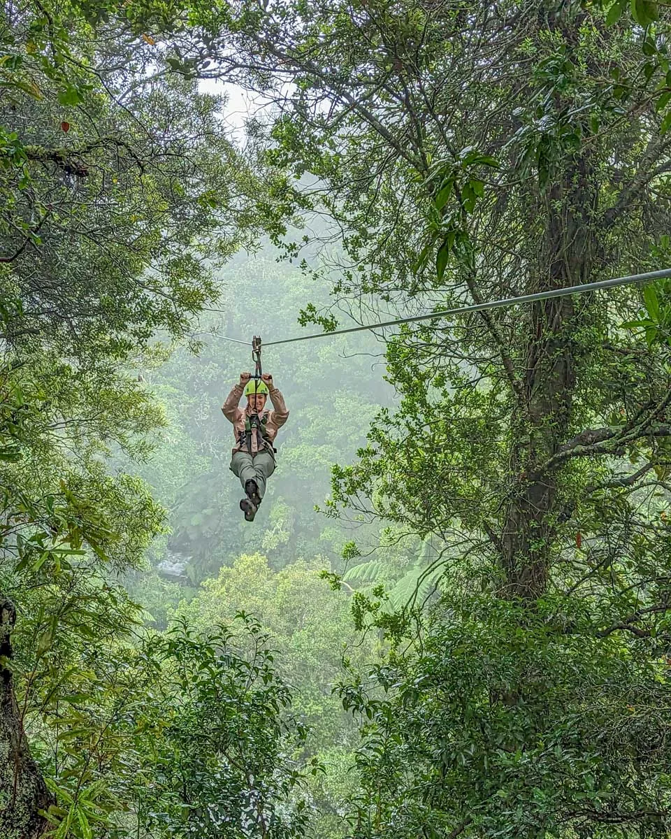 A lady ziplines through the trees in Monteverde, Costa Rica