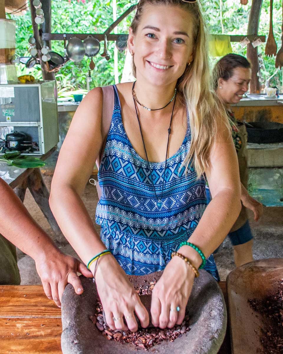 Bailey grinds Cacao Beans on a chocolate tour in Costa Rica