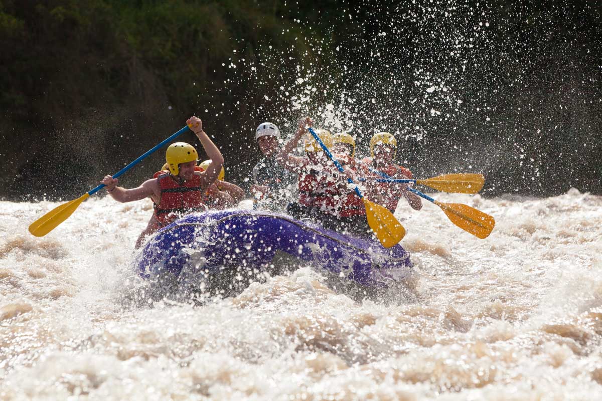 Waves splash over the side of a raft while white water rafting in Costa Rica