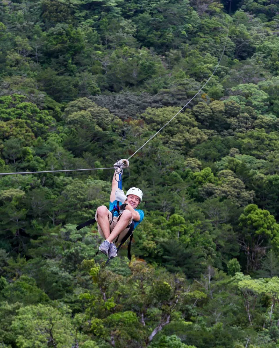 A man ziplining in La Fortuna, Costa rica through the jungle